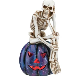 National Tree Company 11 in. Halloween Skeleton Resting on a Purple Galaxy Jack O Lantern